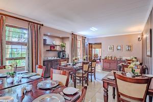 a dining room with tables and chairs and a kitchen at Lourie Lodge in Johannesburg