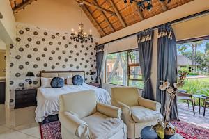 a bedroom with a bed and two chairs at Lourie Lodge in Johannesburg +117 photos