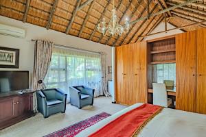 a bedroom with a bed and a desk and a television at Lourie Lodge in Johannesburg