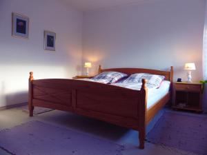 a bedroom with a wooden bed with two night stands and two lamps at Ferienwohnung Asenberg in Bad Salzuflen