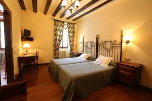 a bedroom with two beds and a table and a lamp at Posada Palacio de Beola by Clabao in Almándoz