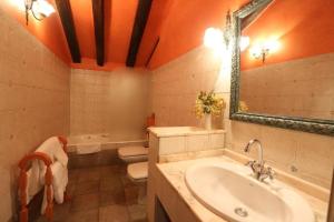 a bathroom with a sink and a toilet and a mirror at Posada Palacio de Beola by Clabao in Almándoz +6 photos