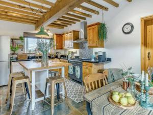 a kitchen with wooden cabinets and a table and chairs at 3 Bed in Matlock oc-86482 in Cuckney