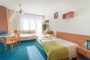 a bedroom with two beds and a table with a laptop at Nasz Dom in Kościelisko +29 photos
