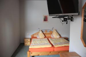 a bedroom with a bed and a flat screen tv at Ferienhaus Grasse in Görlitz