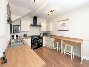 a kitchen with white cabinets and a counter with stools at 2 Bed in Lockerbie oc-94304 in Brydekirk