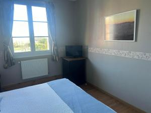 a bedroom with a bed and a desk and two windows at La villa des palmiers in Soublecause