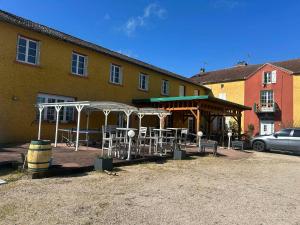 a group of tables and umbrellas in front of a building at La villa des palmiers in Soublecause