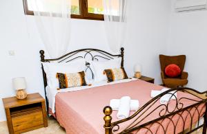 a bedroom with a bed and a chair at Oleander Garden in Alexandroupoli