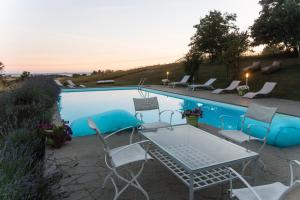 a table and chairs next to a swimming pool at CollinaBlu in Torre San Severo