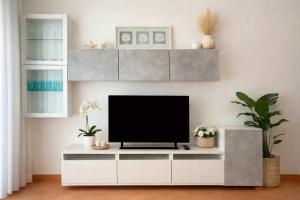 a living room with a tv on a white cabinet at Adamo ed Eva Resort in Numana