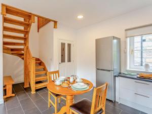 a kitchen and dining room with a table and a refrigerator at 1 Bed in Ardross oc-95533 in Alness
