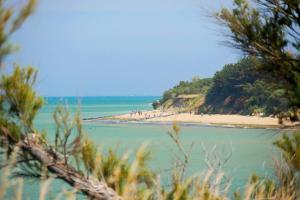 a beach with a group of people standing on the sand at Camping 3 étoiles - Piscine - ccbffbc in Saint-Denis-dʼOléron