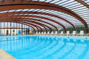 a large swimming pool with chairs and an indoor swimming pool at Camping 3 étoiles - Piscine - ccbffbc in Saint-Denis-dʼOléron