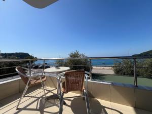 a balcony with a table and chairs and the ocean at Hotel Prinos in Himare