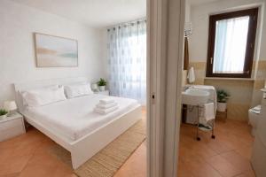 a white bedroom with a bed and a sink at Adamo ed Eva Resort in Numana