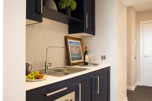 a kitchen with a sink and a bowl of fruit at Metro Hotel Dublin Airport in Santry