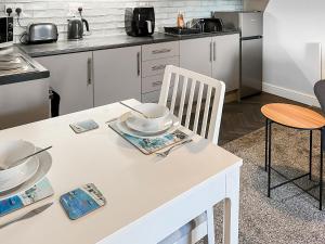 a kitchen with a white table with a white chair at Lily - Uk49362 in Bridlington