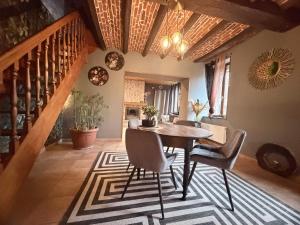 a dining room with a table and chairs on a rug at Suite Home in Crespin