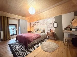 a bedroom with a bed and a brick wall at Suite Home in Crespin