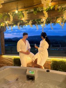 a man and a woman standing next to a bath tub at Tan Y Bryn Glamping in Conwy