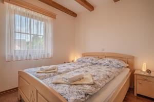 a bedroom with a large bed with towels on it at Vineyard Cottage Stepan in Črnomelj