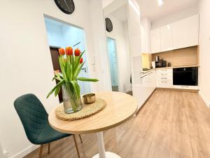 eine Küche mit einem Tisch und einer Vase mit Tulpen in der Unterkunft Virta 8 in Ostróda + 6 Fotos