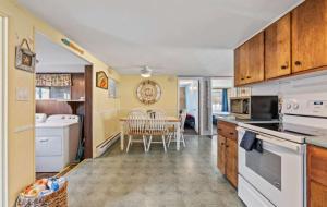 a kitchen with white appliances and a dining room at The Driftwood in Old Orchard Beach