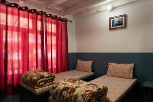 a room with two beds and red curtains at Hotel Sakura in Jomsom