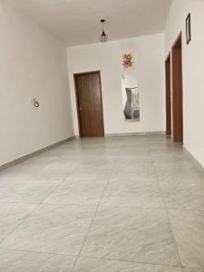 an empty room with white walls and a wooden door at Mimi in Dakar +1 photo