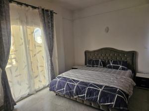a bedroom with a bed and a large window at Mimi in Dakar