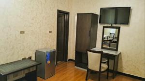 a room with a desk and a computer and a television at Delano Hotel in Bahir Dar