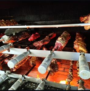 a bunch of food cooking on a grill at Florença Hotel in Quedas do Iguacu