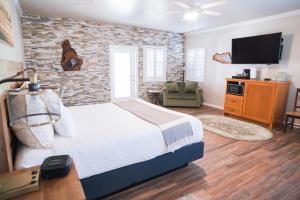 a bedroom with a bed and a brick wall at Grass Valley Courtyard Suites in Grass Valley