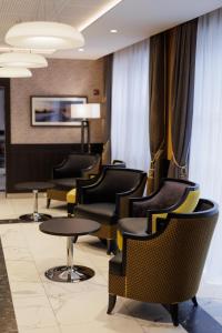 a waiting room with chairs and tables and curtains at Appart One Chambéry in Chambéry