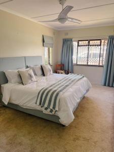 a large bed in a bedroom with blue curtains at Preston House in Park Rynie