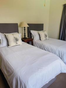 two beds in a hotel room with white sheets at Preston House in Park Rynie +2 photos