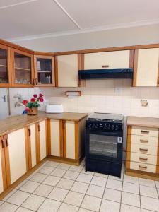 a kitchen with wooden cabinets and a black oven at Preston House in Park Rynie
