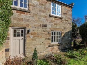 a brick house with a white door and windows at Holly Cottage in Whitby