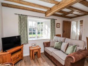 a living room with a couch and a tv at Holly Cottage in Whitby