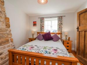 a bedroom with a bed and a brick wall at Holly Cottage in Whitby