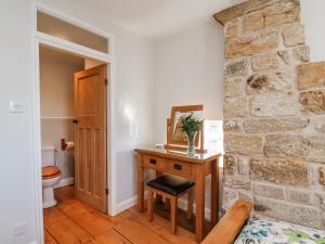 a bathroom with a wooden table and a stone wall at Holly Cottage in Whitby +30 photos