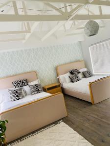 two beds sitting in a room with at De Ocean Lane Guest House in Cape Town +132 photos
