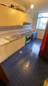 a kitchen with yellow cabinets and a blue tile floor at Daboussi Home in Apúlia