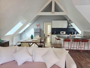 a living room with a couch and a kitchen at Appartement au port Le Mont-Saint-Michel in Dinan