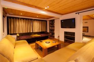 ein Wohnzimmer mit 2 Sofas und einem TV in der Unterkunft Altitude Lodge in Les Gets