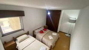 a small room with two beds and a window at Daboussi Home in Apúlia
