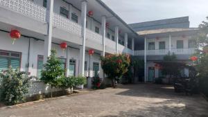a large white building with red lanterns on it at Tanah merah guest house in Singkawang