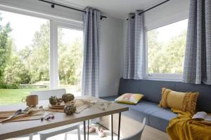 a living room with a blue couch and a table at Camping 3 étoiles - Piscine - à 2 minutes des plages in Penvénan