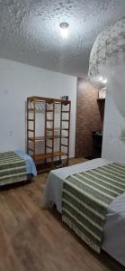 a bedroom with two beds and a book shelf at Espaço MV Family in Prado